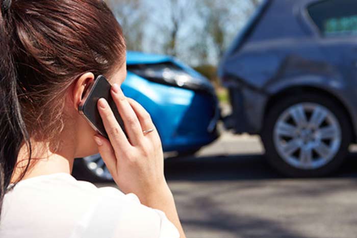 woman at accident calling on phone